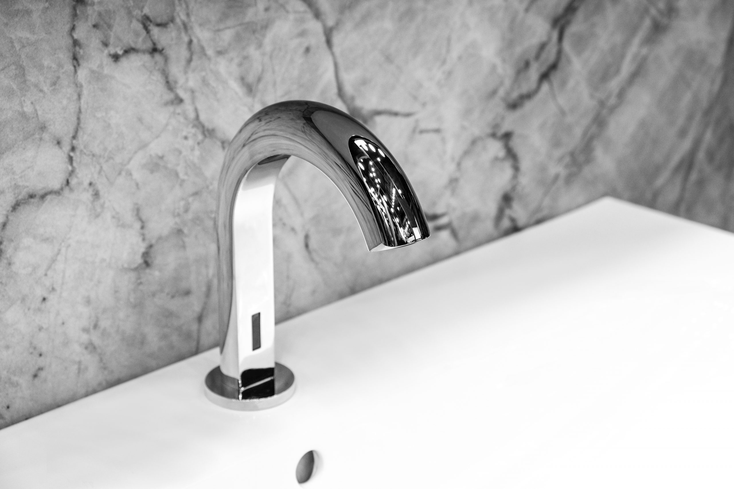  Luxury infrared faucet mixer on a white sink in a beautiful white and gray bathroom